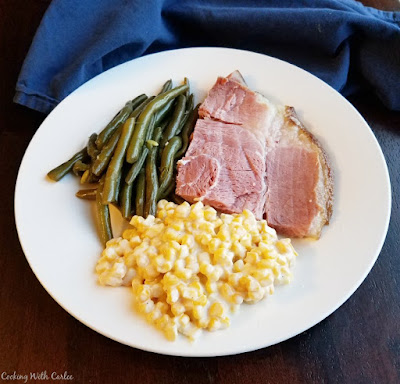 This corn is soooo good. It is creamy and easy and cooks in the slow cooker freeing you up to do other things! It is a perfect side dish for almost any dinner and one the family is sure to love! ham, green beans and creamy corn on dinner plate