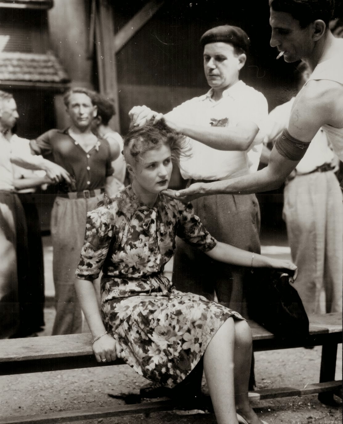 a French woman having her head shaved following liberation, as punishment for an on-going relationship with a Nazi soldier during the occupation of France