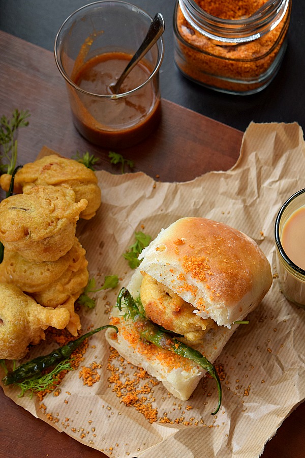 top look of restaurant style vada pav with fried chili,garlic chutney,with cutting chai,date sweet chutney