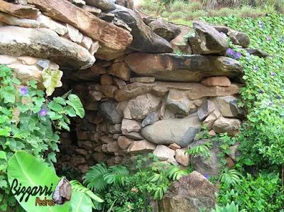 Detalhe da construção da gruta de pedra, da entrada da gruta, com pedra moledo e a execução do paisagismo.