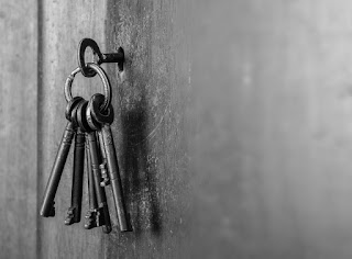 5 metal keys hanging from a ring with one inserted into a door lock to symbolize succeeding as a new manager