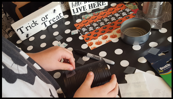 adding the glue dots to the can to cover with a pumpkin