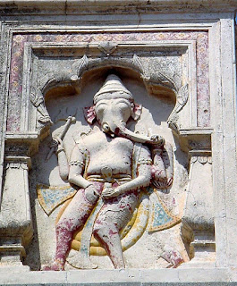 panel displays figurines of Ganesha in a female form as Lambodari, Ganeshwari and Ganeshyani, Shiva / Maheshwari and a third deity, all flanked by dragon like creatures from either side . 