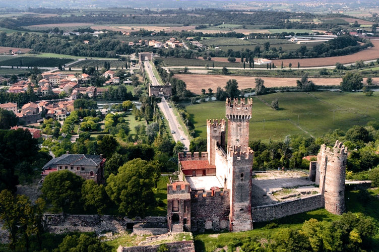 Aerial view of Scaligero Castle in foreground with the Visconti Bridge stretching behind. To the left, the River Mincio and Borghetto. Photo: Courtesy of Tourism.Verona.it.
