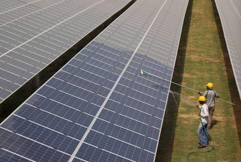 trabalhadores numa central de energia solar na Índia