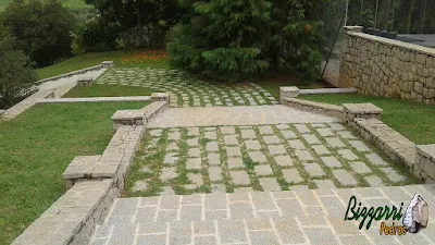 Escada de pedra folheta com as muretas de pedra com as capas e revestimento de pedra, muro e o piso de pedra com juntas de grama em sede da fazenda em Atibaia-SP.
