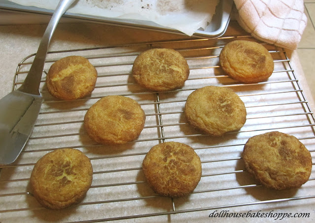 snickerdoodle cookies set on a cooling rack with a spatula and baking tray nearby