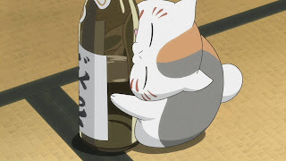 Nyanko-sensei gryzie butelkę sake