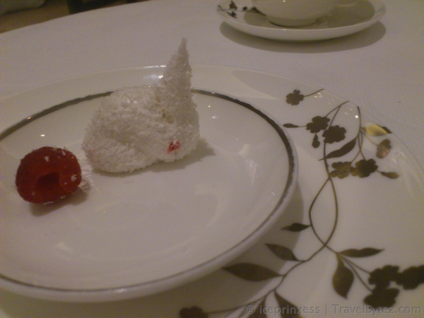 adorable little white fluffy bunny made out of egg whites and grated coconut with some raspberry on the side
