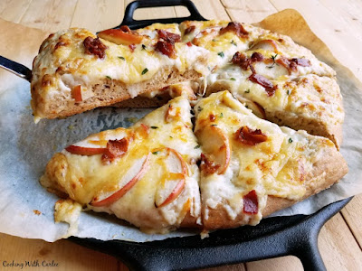 This pizza is loaded with delicious gooey cheese, bacon, apples and thyme. You will not believe how creamy and delicious it is, not to mention how good it smells! lifting slice of creamy cheesy apple pizza