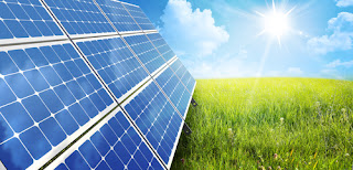 sun shinning, field of grass with close-up of solar panel on left
