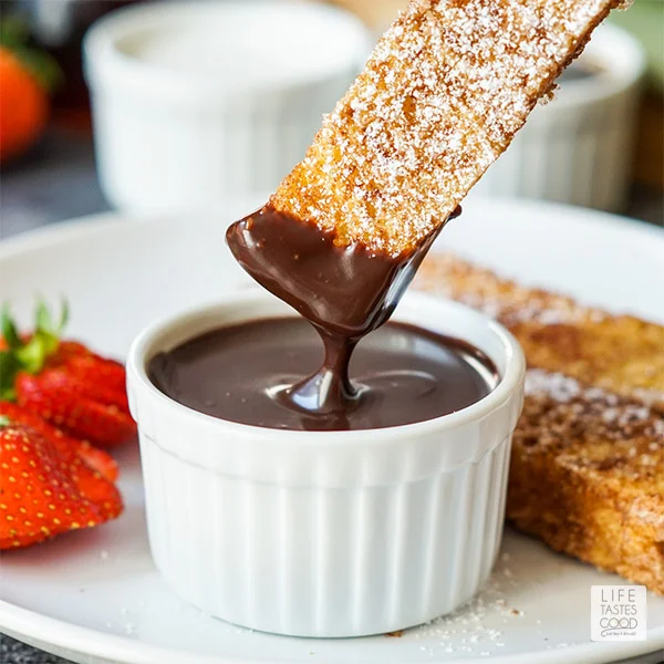 French Toast Sticks being dipped into a decadent chocolate sauce