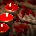 Three red candles with rose petals