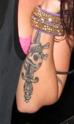 vemos a una mujer joven con tatuaje de cuchillo o tatuaje de daga