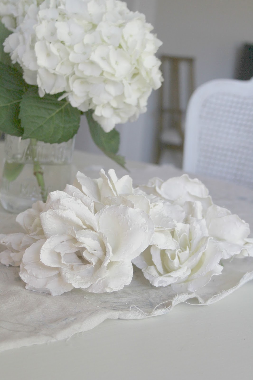 White plaster roses on linen cloth by Hello Lovely Studio