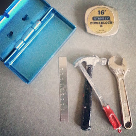 One-twelfth scale miniature toolbox with steel ruler, hammer, screwdriver, spanner and measuring tape.