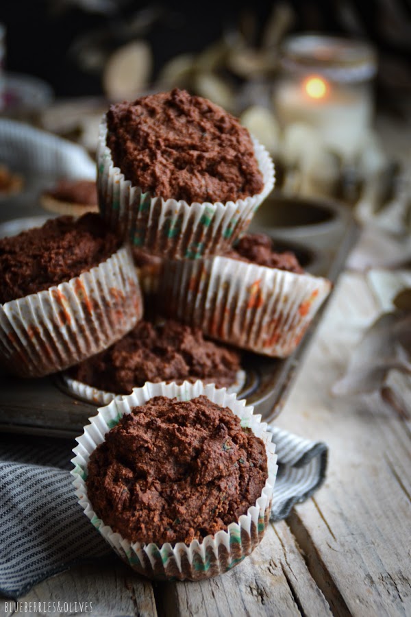Muffins amontonados, bandeja metálica retro, mesa madera envejecida, vela encencida, ramas secas eucalipto,