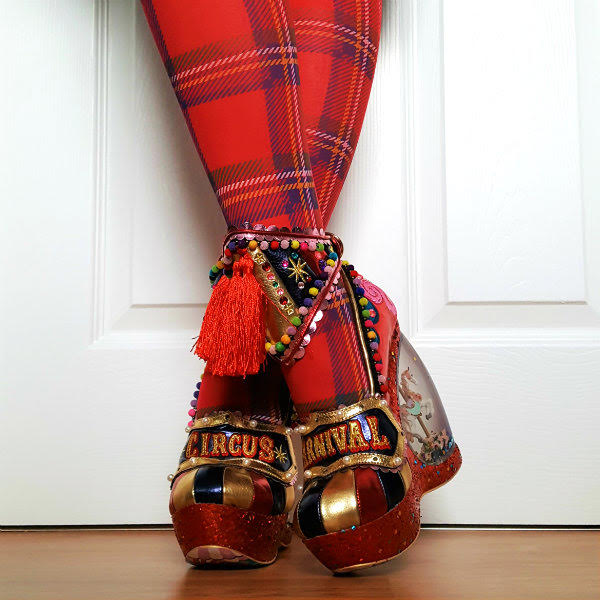 Irregular Choice You're Invited circus themed shoes crossed legs wearing tassel ankle cuffs and circus themed platform shoes