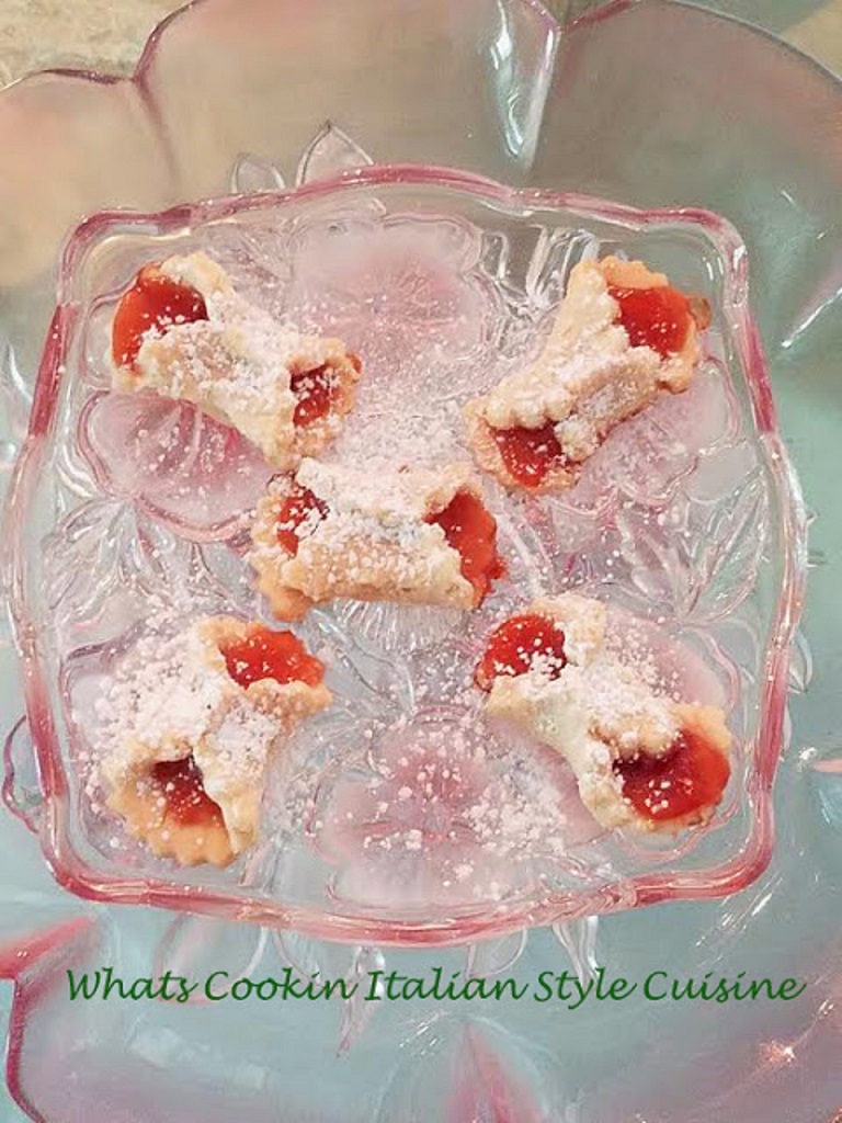 a jam filled Italian Cookie Shaped into bow ties with powdered sugar