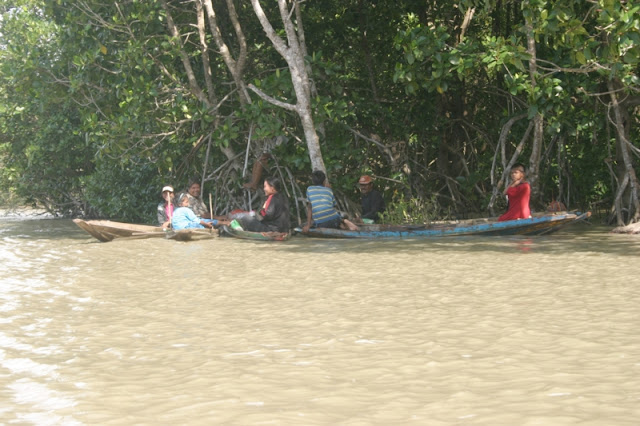 Monsoon rains and  tidal waters keeps changing water levels.  Locals hanging out on their boats.
