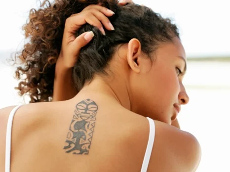 tatuagem em pele negra nas costas feminina