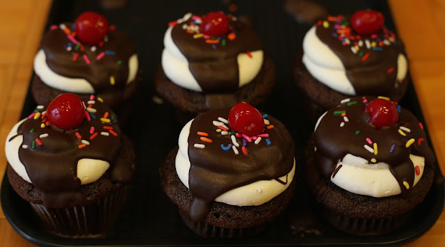 Cupcakes de chocolate con chispas de colores y cereza