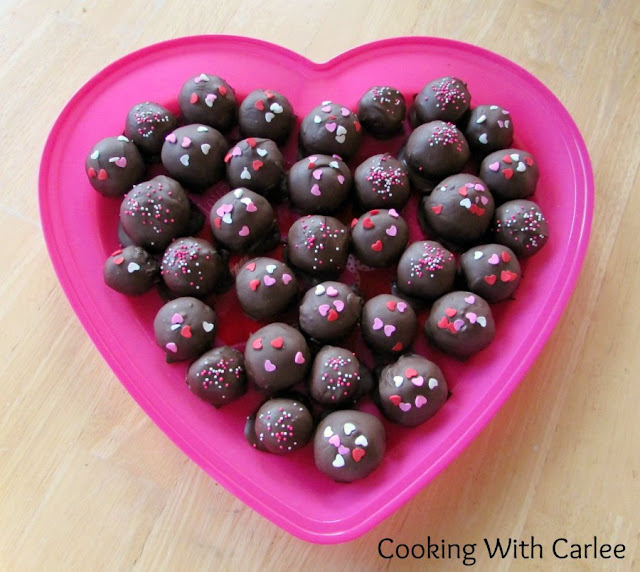 These sweet little rum balls will make you feel the burn! Perfect for your Valentine or as a holiday treat. They are a little bit nice with the chocolate and a little bit naughty with the booze! heart shaped platter filled with chocolate dipped rum balls
