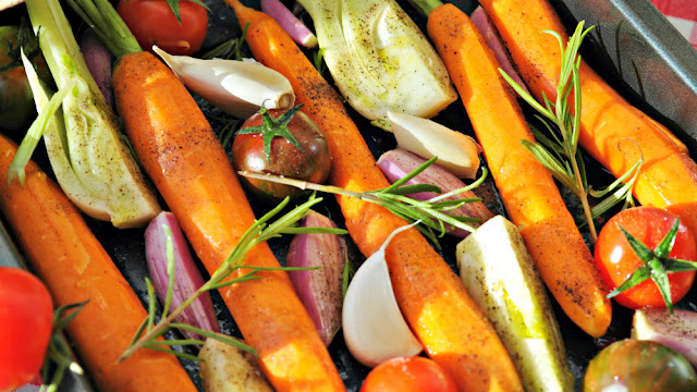 A variety of vegetables (carrots, onions, tomatoes, garlic and rosemary) to add to your homemade chicken stock or broth for deeper, richer flavor.