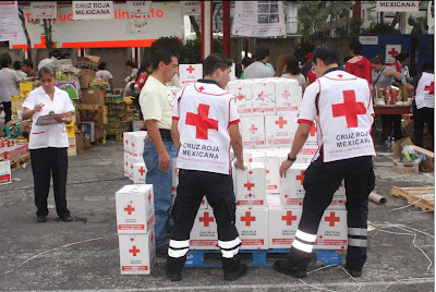 Voluntarios de la Cruz Roja armando ayuda humanitaria.
