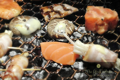 The mushroom wrapped in bacons and salmon on grill in TANBA Japanese BBQ