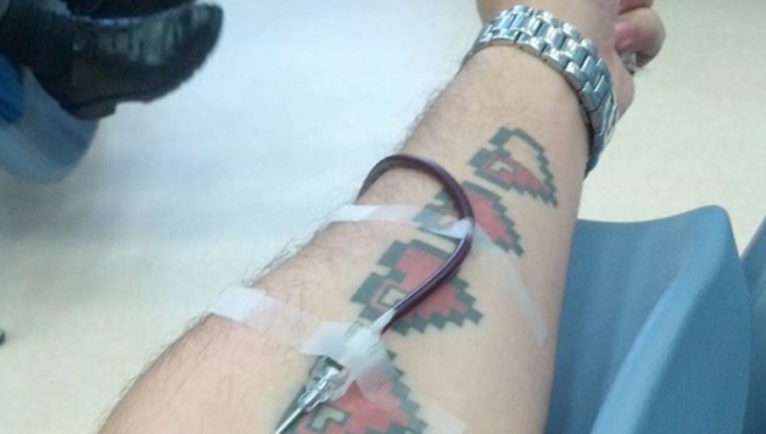 Un hombre tatuado dando sangre