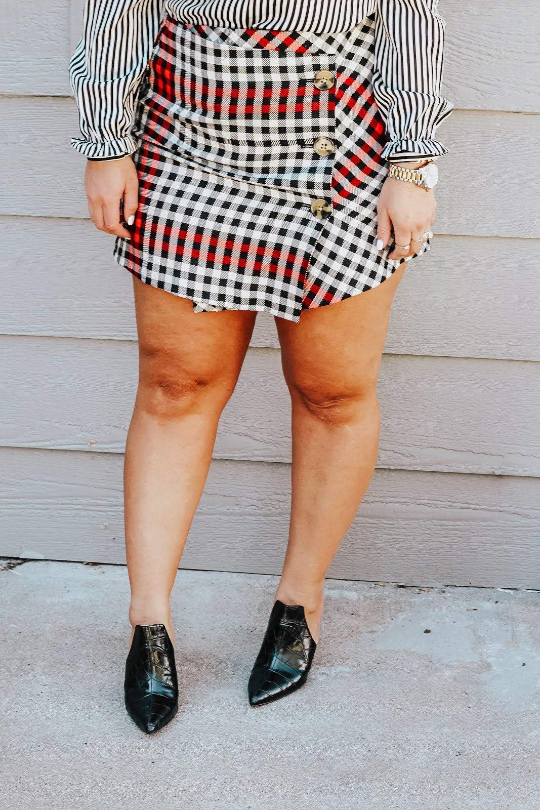 Plaid mini skirt styled for Fall, featured by top Denver fashion blog, Delayna Denaye: blonde woman smiling and wearing a Who What Wear plaid mini skirt, Who What Wear mule pumps, Who What Wear striped ruffle blouse, Amazon bangle and Michael Kors watch