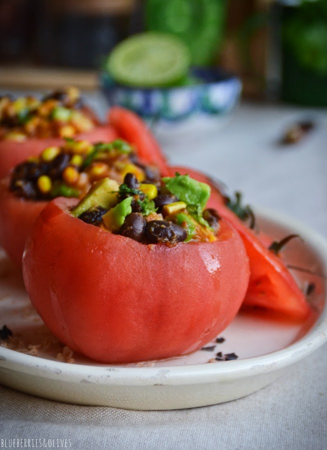 Tomates rellenos ensalada texmex en fuente porcelana blanca, fondo madera, cilantro, ingredientes