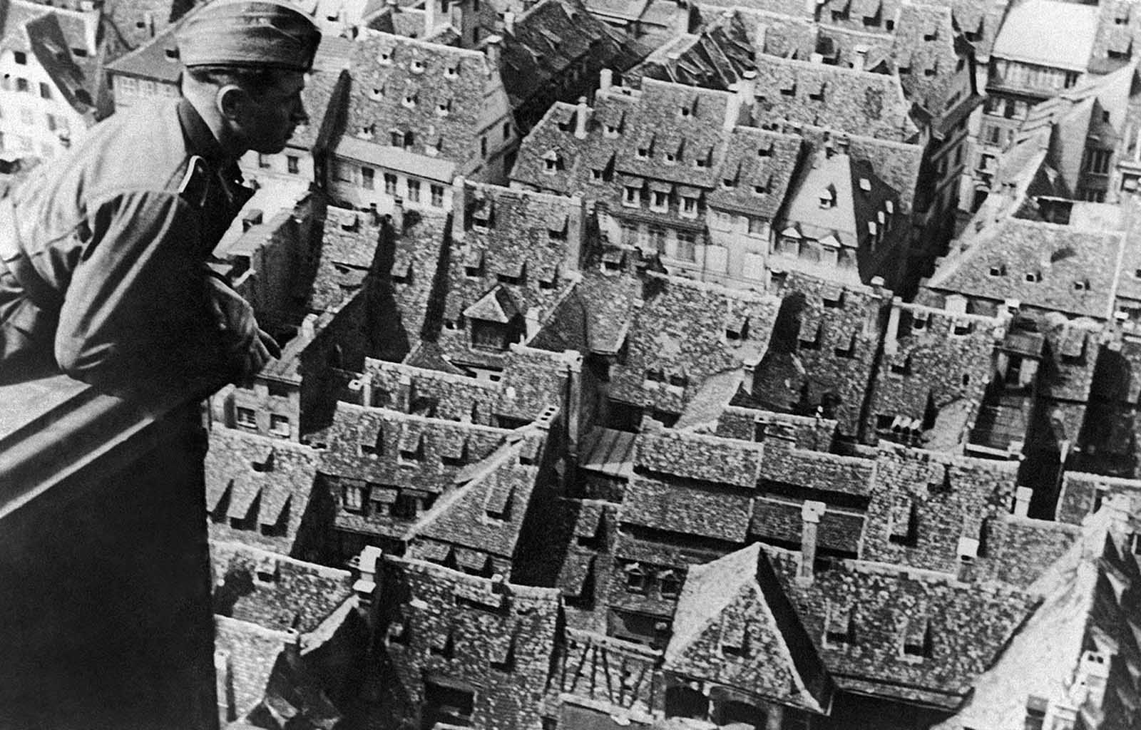 A German soldier stands in the tower of the cathedral, gazing down upon the captured French city of Strasbourg on July 15, 1940. Adolf Hitler visited the city in June of 1940, declaring plans for the Strasbourg Cathedral, stating that it should become a 
