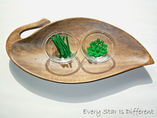 Stringing two green beads to represent the Montessori bead bar.