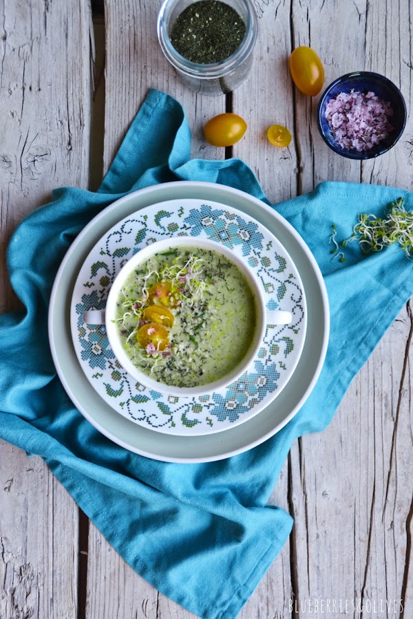 SOPA CRUDA CALABACÍN EN TAZONES PORCELANA BLANCA Y TURQUESA FLORIDA, MANTEL AZUL Y MESA MADERA VIEJA