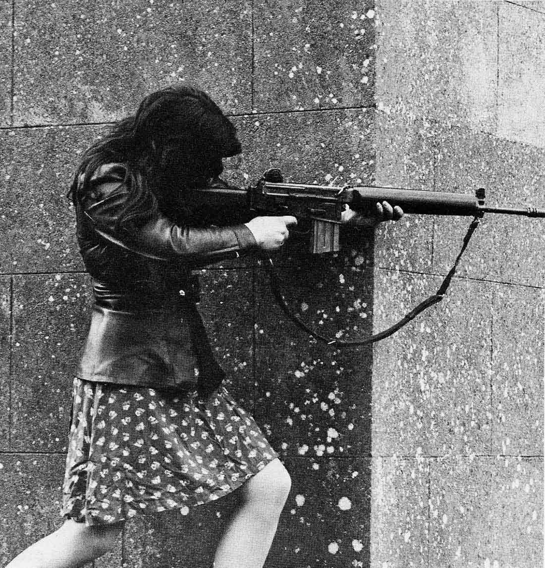 A woman IRA volunteer on active service in West Belfast with an AR18 assault rifle.
