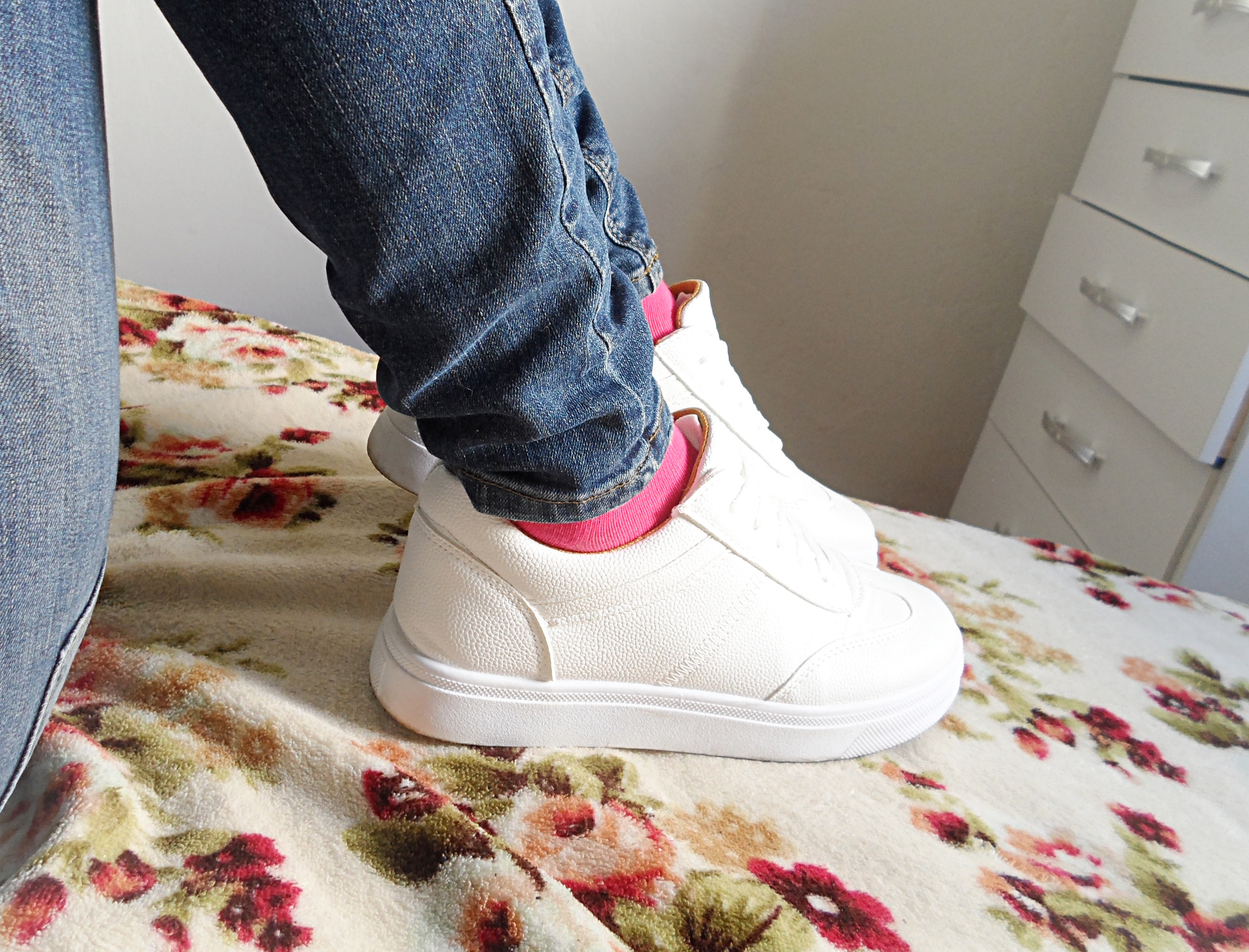 close up of legs in jeans and socks wearing white basic sneakers