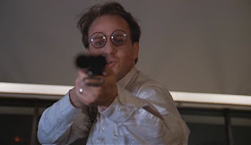 Bobcat Goldthwaite holding a gun in Scrooged 1988 movieloversreviews.filminspector.com