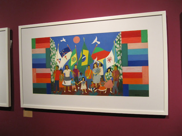 A obra Independência mostra várias pessoas (desde crianças até adultos) carregando mastro com bandeiras estaduais e do Brasil.
