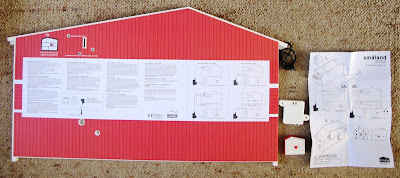 Rear of a Lundby Smaland 2015 dolls' house, showing remote-controlled lighting unit instructions, with the unit components next to it.