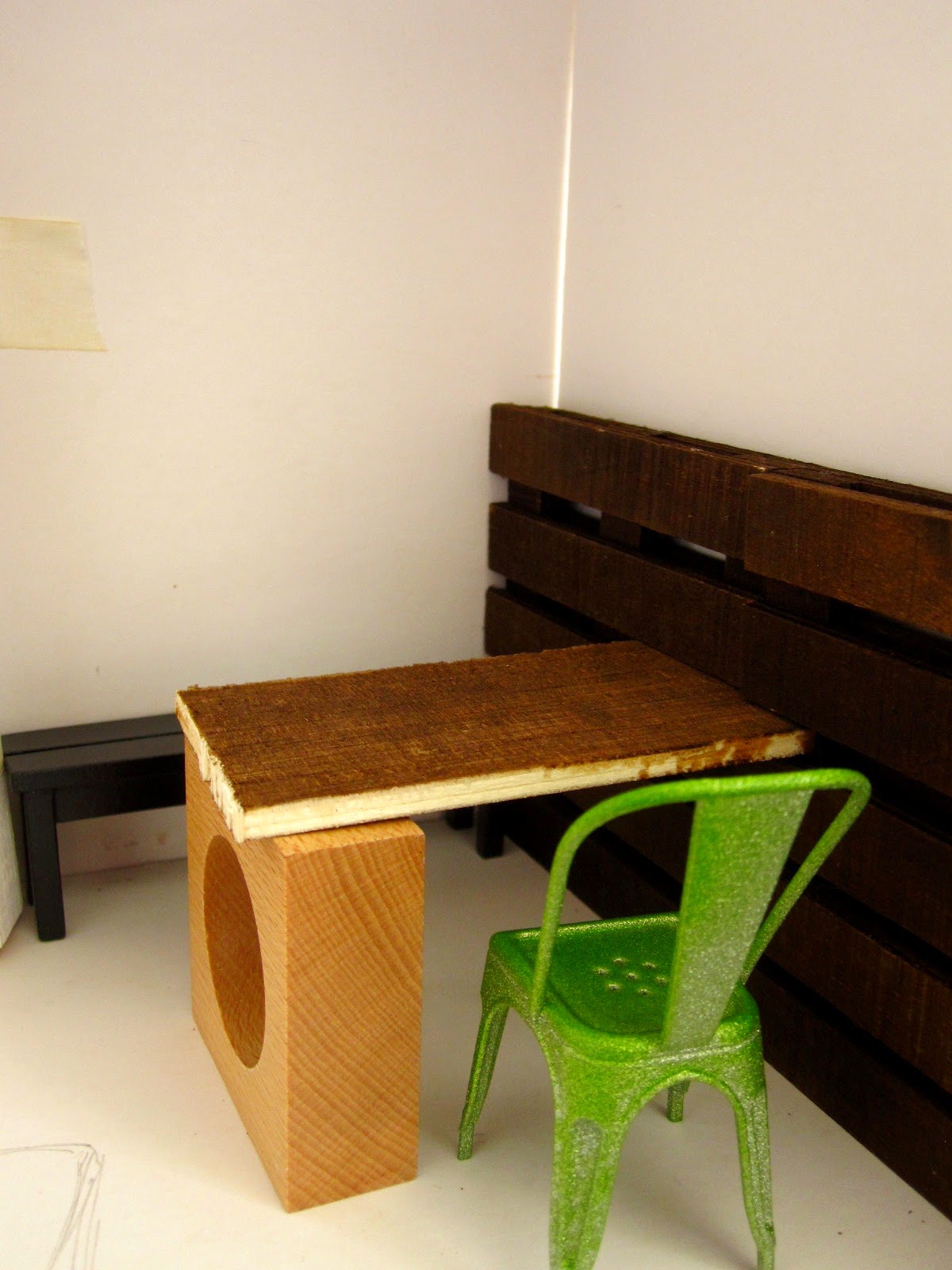 Modern dolls' house miniature cafe, half built with mock up of a table and chairs set up.