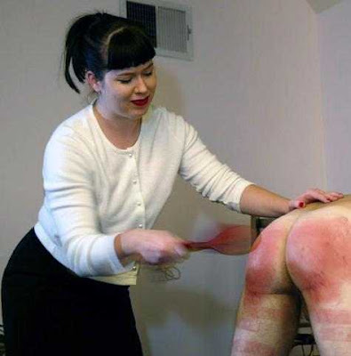 femdom bdsm woman spanking man's ass black and blue with a paddle