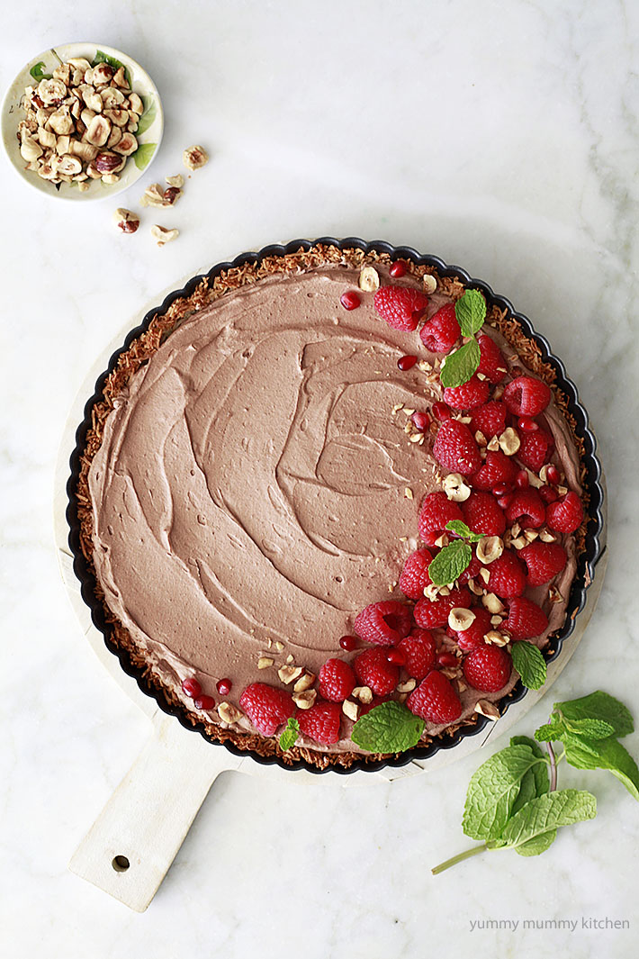 vegan coconut chocolate mousse pie Vegan coconut chocolate mousse pie with coconut crust, raspberries, and hazelnuts.