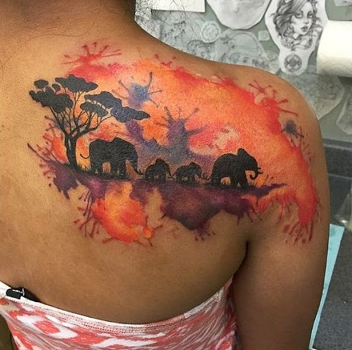 A silhueta de uma manada de elefantes andando tronco e cauda, é embelezado com uma variedade de manchas de aquarela.