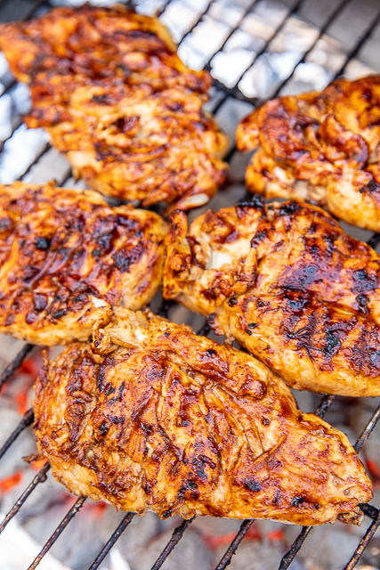 Apple BBQ Grilled Chicken - only 4 ingredients including the chicken! SO good!!! We actually made it twice in one week. Apple juice, brown sugar, BBQ sauce and chicken. We like to brush the chicken with extra BBQ sauce before taking it off the grill. Such an easy weeknight meal. Great as a main dish, on top of a salad or chopped up in a wrap! The whole family LOVES this easy grilled chicken recipe! #grilling #chicken #bbq #grilledchicken BBQ chicken on the grill