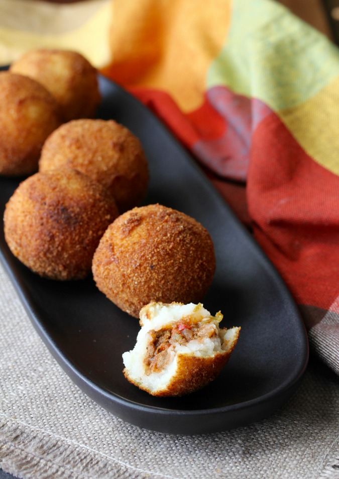 Cuban Papas Rellenas are mashed potatoes stuffed with seasoned meat, rolled into a ball, breaded, and then deep fried, resulting in these little packages of pop-able deliciousness.