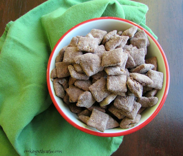 That childhood favorite snack of yours just got an upgrade! Whether you call it puppy chow, muddy buddies or just plain good, you have to try this brownie batter version! looking down at bowl of brownie batter muddy buddies ready to eat