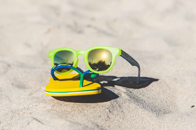 Ipanema Sonnenbrille und Sandalen in gelb und grün mit Sonne am Strand