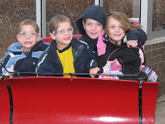 Four kids in a no horse open sleigh